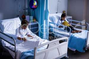 Patients with digital tablet and book sitting on bed