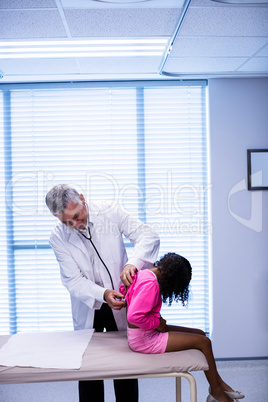 Doctor examining patient with stethoscope