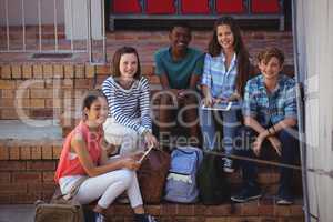 Students using digital tablet on staircase