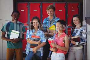 Students holding books standing in school campus