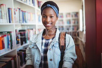 Portrait of smiling schoolgirl in library