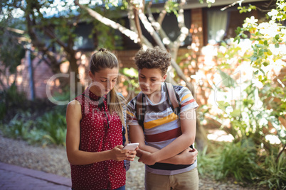 Classmates using mobile phone