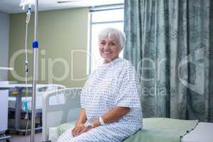 Portrait of smiling senior patient on bed