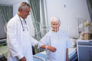 Doctor assisting senior patient in ward