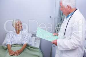 Doctor interacting with senior patient in ward