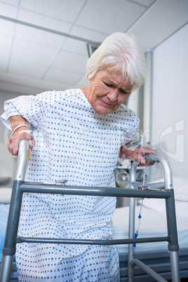 Smiling senior patient holding walking frame to get up