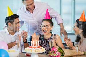Smiling colleagues celebrating birthday of woman