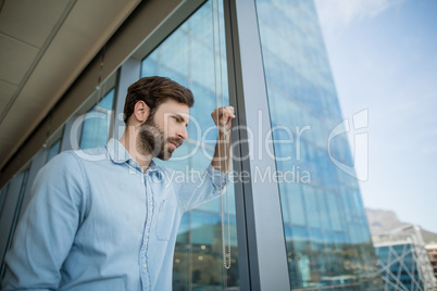 Thoughtful business executive standing in corridor