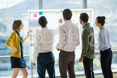 Group of business executives looking at white board