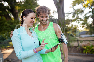 Couple looking at smartphone while jogging