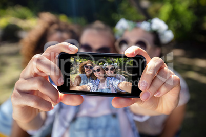 Female friends taking selfie with mobile phone