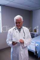 Male doctor using digital tablet in ward