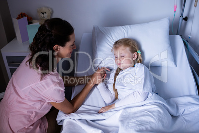 Female doctor consoling patient during visit in ward