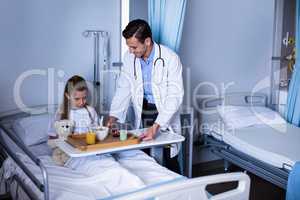 Doctor serving breakfast to girl