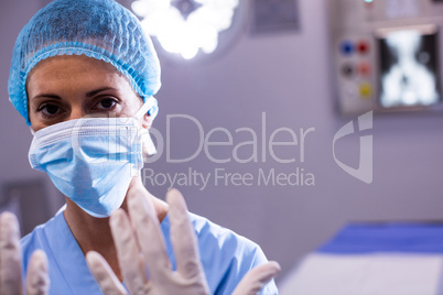 Portrait of female surgeon preparing for operation in operation room