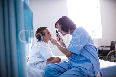 Female doctor examining patient eye using ophthalmic device