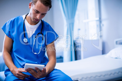 Doctor using digital tablet in ward