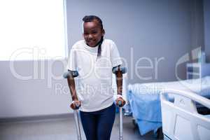 Portrait of girl walking with crutches in ward
