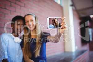 Schoolgirls taking selfie on mobile phone