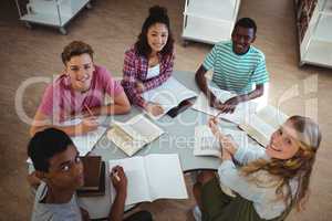 High angle view of happy classmates studying in library