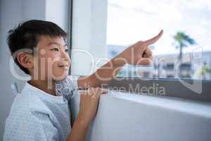 Boy patient pointing out from the window