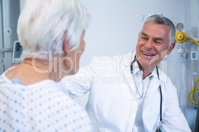 Doctor interacting with senior patient in ward