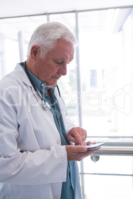 Doctor holding smartphone in the passageway