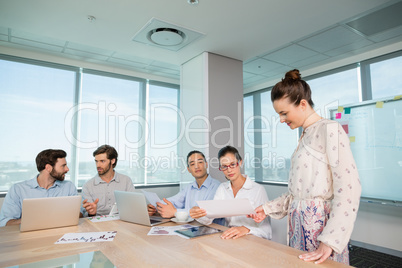 Business executives discussing with each other in conference room