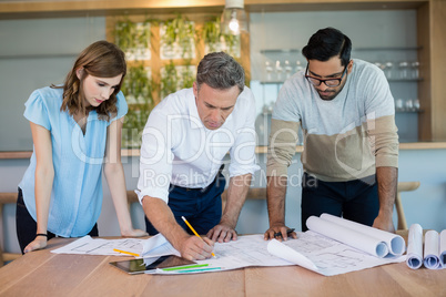 Architects working over blueprint in conference room