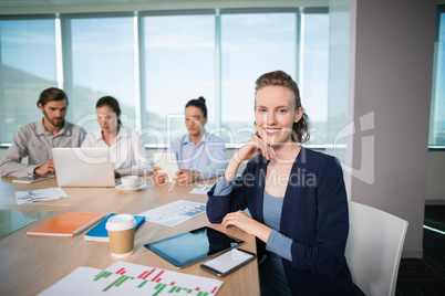 Portrait of smiling female business executive sitting in conference room