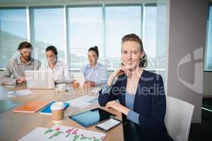 Portrait of smiling female business executive sitting in conference room