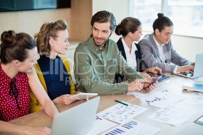 Smiling business team interacting with each other in conference room