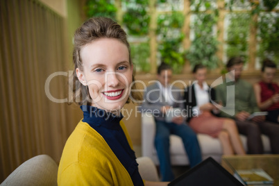 Business executive smiling while sitting in office lobby