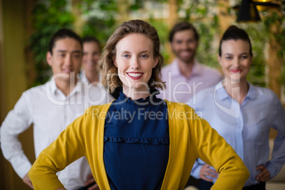 Business executives with hands on hip smiling while standing in office