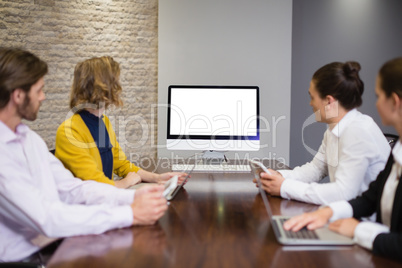Business team looking at computer screen in the meeting room