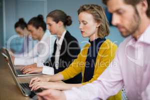 Business executives using electronic devices on conference table