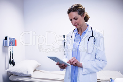 Doctor using digital tablet in ward