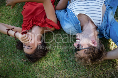 Couple lying on grass in park