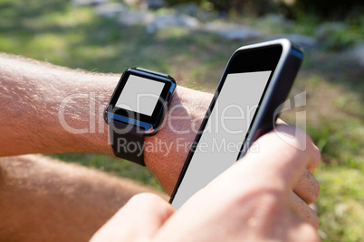 Man hands wearing smart watch and using mobile phone