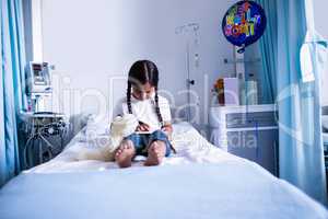 Patient using digital tablet on bed