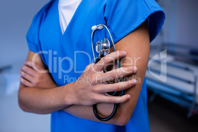 Male doctor holding stethoscope in ward at hospital