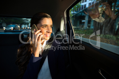 Business executive talking on mobile phone in car