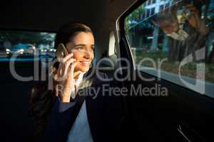 Business executive talking on mobile phone in car