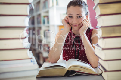 Portrait of happy schoolgirl studying library
