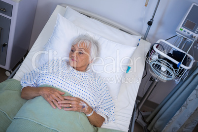 Thoughtful senior patient lying on bed