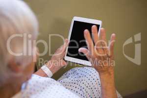Senior patient using digital tablet to video chat