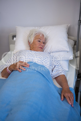 Thoughtful senior patient lying on bed