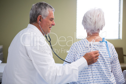 Doctor examining senior patient with stethoscope