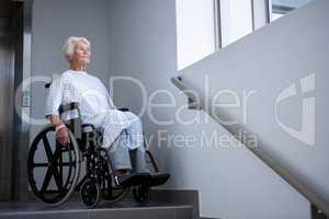 Disabled senior patient on wheelchair near staircase