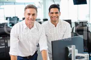 Portrait of smiling business colleagues working at desk